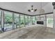 Bright sunroom with tile flooring, a fireplace, and large windows overlooking the backyard at 5309 Overtop Ln, Raleigh, NC 27613