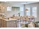 Open-concept dining area with modern light fixture, dining table, and large windows that provide natural light and green backyard views at 554 Beacon Ridge Blvd, Chapel Hill, NC 27516