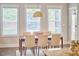 Dining room filled with natural light, featuring a wooden table with seating for six, complemented by a neutral rug and decor at 554 Beacon Ridge Blvd, Chapel Hill, NC 27516