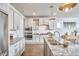 Bright kitchen features white cabinetry, stainless steel appliances, and granite countertops, complemented by modern pendant lighting at 554 Beacon Ridge Blvd, Chapel Hill, NC 27516