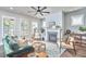 Bright living room featuring a fireplace, ceiling fan, and ample natural light from the multiple windows at 554 Beacon Ridge Blvd, Chapel Hill, NC 27516
