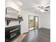 Living room featuring a fireplace, dark wood floors, ceiling fan, and sliding door to the patio at 600 Audubon Lake Dr # 4B11, Durham, NC 27713
