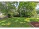 Expansive backyard featuring a well-manicured lawn and mature trees, creating a serene outdoor space at 601 E Franklin St, Raleigh, NC 27604