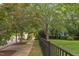 Charming street view with a black fence, sidewalk lined with trees, and a well-maintained lawn at 601 E Franklin St, Raleigh, NC 27604