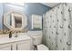 A full bathroom showcasing white cabinets, a decorative mirror and fixtures, and a bathtub with a shower curtain at 601 Texanna Way, Holly Springs, NC 27540