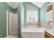 A tub and shower combination and vanity area with natural light and tasteful decor in a well-appointed bathroom at 601 Texanna Way, Holly Springs, NC 27540