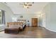 A spacious bedroom with wood laminate flooring, a bed with a patterned comforter, and a ceiling fan at 601 Texanna Way, Holly Springs, NC 27540