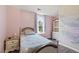 Cozy bedroom with a twin bed, a window with curtains, and soft pink walls at 601 Texanna Way, Holly Springs, NC 27540
