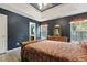 A bedroom with an open door into a connecting bathroom, a wooden bedframe, and wood laminate flooring at 601 Texanna Way, Holly Springs, NC 27540