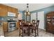 Eat-in kitchen with stainless steel appliances, wood cabinets, and dining area with seating at 601 Texanna Way, Holly Springs, NC 27540