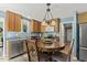 Eat-in kitchen with wood cabinets, stainless steel appliances, and a dining area with seating for four at 601 Texanna Way, Holly Springs, NC 27540