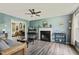 Cozy living room with a fireplace, hardwood floors, ceiling fan, and a glimpse into another room at 601 Texanna Way, Holly Springs, NC 27540