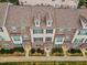 Aerial view of brick and tan townhomes with well-manicured green lawns and blue shutters at 6027 Kentworth Drive. Dr, Holly Springs, NC 27540