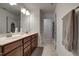 Bright bathroom featuring a double sink vanity with drawers and a hallway with doors on either side at 6027 Kentworth Drive. Dr, Holly Springs, NC 27540