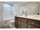 Well lit bathroom featuring a shower-tub combo and a vanity with dark wood cabinets at 6027 Kentworth Drive. Dr, Holly Springs, NC 27540
