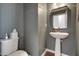 Modern half bathroom with a pedestal sink, toilet, and elegant mirror at 6027 Kentworth Drive. Dr, Holly Springs, NC 27540