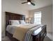 Well-lit bedroom showcasing a dark wood bed frame, neutral bedding, and a ceiling fan at 6027 Kentworth Drive. Dr, Holly Springs, NC 27540