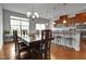 Open dining area with hardwood floors, stylish chandelier, and breakfast bar adjacent to the modern kitchen at 6027 Kentworth Drive. Dr, Holly Springs, NC 27540