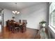 A dining room with wood floors, a chandelier, a table with chairs and a plant at 6027 Kentworth Drive. Dr, Holly Springs, NC 27540