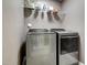 Modern laundry room with gray walls, shelving, and a modern, front-loading washer and dryer at 6027 Kentworth Drive. Dr, Holly Springs, NC 27540
