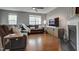 Cozy living room with a plush sectional sofa, fireplace, and gleaming hardwood floors at 6027 Kentworth Drive. Dr, Holly Springs, NC 27540