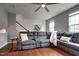 Living room with a plush gray sectional, hardwood floors and a ceiling fan at 6027 Kentworth Drive. Dr, Holly Springs, NC 27540