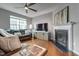 Comfortable living room features a corner fireplace, ceiling fan, and modern furnishings at 6027 Kentworth Drive. Dr, Holly Springs, NC 27540