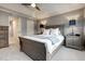 Inviting main bedroom with a ceiling fan, tray ceiling, and decorative lamps on nightstands at 6027 Kentworth Drive. Dr, Holly Springs, NC 27540
