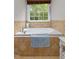Bathroom featuring tiled tub and a window providing natural light and lush green scenery at 603 Edburton Ct, Hillsborough, NC 27278