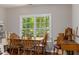 Bright dining room featuring hardwood floors and a large window with a view of the surrounding greenery at 603 Edburton Ct, Hillsborough, NC 27278