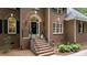 Home's brick front entrance features a wreath and decorative plants and is inviting at 603 Edburton Ct, Hillsborough, NC 27278