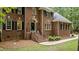 Traditional brick home featuring arched windows, dark shutters, a wreath, and manicured landscaping at 603 Edburton Ct, Hillsborough, NC 27278