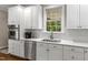 Well-lit kitchen featuring white cabinets, stainless steel appliances, and elegant countertops at 603 Edburton Ct, Hillsborough, NC 27278