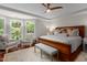 Spacious main bedroom with hardwood floors, ceiling fan, large windows, and elegant furnishings at 603 Edburton Ct, Hillsborough, NC 27278