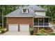 Brick home's back showcases a two-car garage, screened porch and upper dormer window at 603 Edburton Ct, Hillsborough, NC 27278