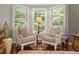Bedroom sitting area featuring classic chairs, hardwood flooring, and views of the lush greenery at 603 Edburton Ct, Hillsborough, NC 27278