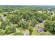 An aerial view captures a charming house nestled among lush trees in a tranquil, residential neighborhood at 619 S Fifth St, Mebane, NC 27302