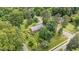 A cozy one-story brick home is surrounded by mature trees and a well-manicured lawn and landscaping at 619 S Fifth St, Mebane, NC 27302