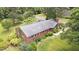 Aerial view of a charming brick home with lush landscaping, a well-manicured lawn, and mature trees, showcasing curb appeal at 619 S Fifth St, Mebane, NC 27302