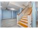Finished basement with staircase, light gray vinyl floors, and updated lighting at 619 S Fifth St, Mebane, NC 27302