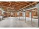 Unfinished basement with exposed ceiling, brick walls, concrete floor, and support beams, offering potential for customization at 619 S Fifth St, Mebane, NC 27302