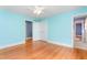 Light-filled bedroom with blue walls, wood floors, closet, and white trim throughout the space at 619 S Fifth St, Mebane, NC 27302