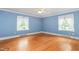 Comfortable bedroom with hardwood floors, a ceiling fan, and two windows offering natural light at 619 S Fifth St, Mebane, NC 27302