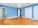 Bright bedroom with hardwood floors and closet doors, complemented by the adjacent bathroom with a vanity and tub at 619 S Fifth St, Mebane, NC 27302