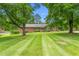 Attractive brick home featuring a well-manicured front yard and mature trees at 619 S Fifth St, Mebane, NC 27302