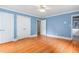 This spacious main bedroom offers hardwood floors, a ceiling fan, and a glimpse into the bathroom at 619 S Fifth St, Mebane, NC 27302