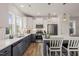 A bright, modern kitchen with white cabinetry, stainless steel appliances, and a stylish breakfast bar at 710 Vine Pkwy, Pittsboro, NC 27312