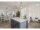 Well-lit kitchen featuring an island with a white countertop and dark cabinets, and modern lighting at 710 Vine Pkwy, Pittsboro, NC 27312