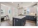 Well-lit kitchen featuring an island with a white countertop and dark cabinets, and modern lighting at 710 Vine Pkwy, Pittsboro, NC 27312
