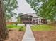 Landscaped backyard with a wooden walkway leading to a deck and screened porch, perfect for relaxation at 7501 Montibillo Pkwy, Durham, NC 27713
